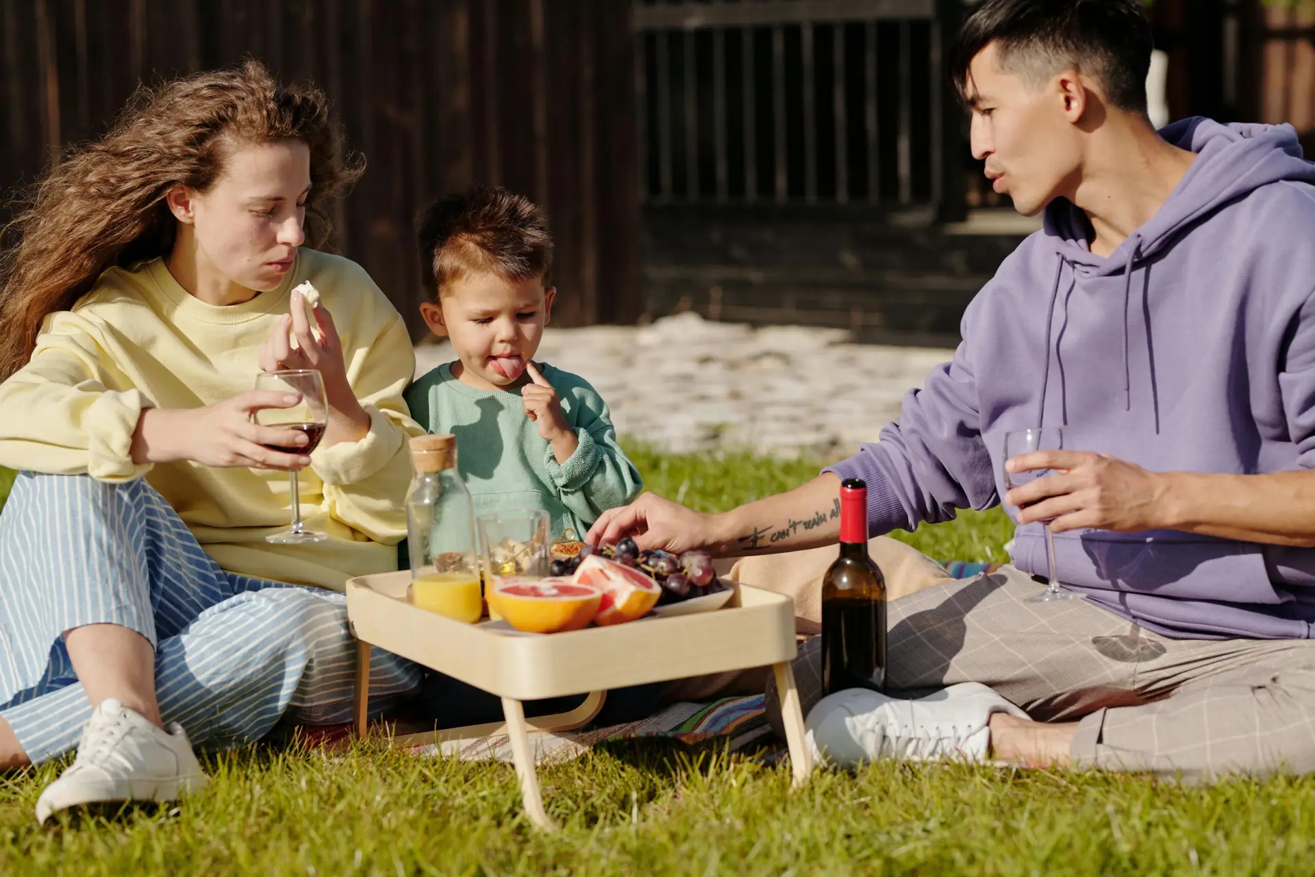 rodzina jedząca na trawie